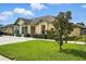 Well-manicured single-story home with vibrant green lawn, manicured shrubs and ample parking at 3280 Villa Way Cir, St Cloud, FL 34769