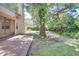 Serene backyard with brick patio, mature trees, and verdant plants creating a peaceful outdoor space at 3519 Gatlin Place Cir, Orlando, FL 32812