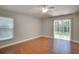 Spacious bedroom with hardwood floors, ceiling fan, and sliding glass door to backyard at 3519 Gatlin Place Cir, Orlando, FL 32812
