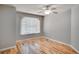 Bright bedroom with hardwood floors, ceiling fan, and a large window at 3519 Gatlin Place Cir, Orlando, FL 32812