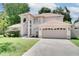 Charming two-story home featuring an arched entryway, attached garage, and beautifully landscaped front yard at 3519 Gatlin Place Cir, Orlando, FL 32812