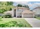 Charming two-story home with landscaped front yard, arched entryway, and a spacious driveway at 3519 Gatlin Place Cir, Orlando, FL 32812