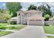 Inviting two-story home featuring well-maintained landscaping, a driveway, and an attached two-car garage at 3519 Gatlin Place Cir, Orlando, FL 32812