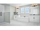 Elegant bathroom with a soaking tub, dual vanities, a glass-enclosed shower, and bright natural light at 426 Veneto Cir, Clermont, FL 34715