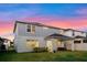 Two-story home with a covered patio and a well-maintained lawn against a colorful sky at 4316 Foggy Oak Ln, Sanford, FL 32773
