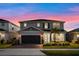 Beautiful two-story home showcasing a two-car garage, manicured lawn, and inviting entrance at twilight at 4316 Foggy Oak Ln, Sanford, FL 32773