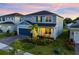 Charming two-story home with a blue exterior, well-manicured lawn, and welcoming front porch with rocking chairs at 4316 Foggy Oak Ln, Sanford, FL 32773