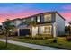 Two-story home boasting a two-car garage, pristine landscaping, and a welcoming facade under a multicolored sky at 4316 Foggy Oak Ln, Sanford, FL 32773