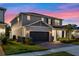 Charming two-story home with a well-manicured lawn and a two-car garage under a colorful dusk sky at 4316 Foggy Oak Ln, Sanford, FL 32773