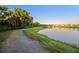 Picturesque view of a scenic lake and walking path surrounded by lush trees and neighborhood houses at 4316 Foggy Oak Ln, Sanford, FL 32773