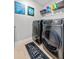 Well-lit laundry room featuring modern washer and dryer, shelving, and tasteful decor at 4316 Foggy Oak Ln, Sanford, FL 32773
