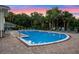 Community swimming pool with lounge chairs and clear blue water under a colorful dusk sky at 4316 Foggy Oak Ln, Sanford, FL 32773