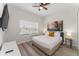 Bright bedroom with a comfortable queen bed, wooden floors, a ceiling fan and a window with blinders at 4974 Windermere Ave, Kissimmee, FL 34746