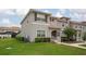Beautiful townhome exterior featuring lush green lawn, landscaped bushes, and a view of neighboring homes at 4974 Windermere Ave, Kissimmee, FL 34746