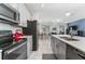 Modern kitchen with stainless steel appliances, granite countertops, and a view of the open-concept living area at 4974 Windermere Ave, Kissimmee, FL 34746