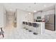 Modern kitchen featuring white marble floors, gray cabinets, stainless steel appliances, and a cozy breakfast bar with stylish seating at 4974 Windermere Ave, Kissimmee, FL 34746
