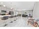 Bright, open-concept living area with sleek modern flooring and lots of natural light; bar seating is available at 4974 Windermere Ave, Kissimmee, FL 34746