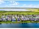 Rear aerial view of a home with a screened-in patio, on the water, and surrounded by other homes at 5029 Hartwell Ct, St Cloud, FL 34771