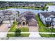 Aerial view of a single-story home with a well-kept lawn, brick driveway, beautiful landscaping and solar panels at 5029 Hartwell Ct, St Cloud, FL 34771