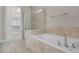 Bathroom featuring tub and shower with tile surround and glass enclosure at 5029 Hartwell Ct, St Cloud, FL 34771