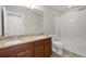 Bathroom featuring double sinks, granite countertops, wood cabinets, and a shower-tub combo at 5029 Hartwell Ct, St Cloud, FL 34771