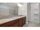 Bathroom with double vanity, granite countertops, and a tiled walk-in shower at 5029 Hartwell Ct, St Cloud, FL 34771