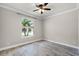 Cozy bedroom featuring wood-look tile flooring, ceiling fan, and a window view at 5029 Hartwell Ct, St Cloud, FL 34771