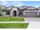 Charming single-story home with a manicured lawn, brick driveway, beautiful landscaping and solar panels at 5029 Hartwell Ct, St Cloud, FL 34771