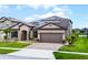Charming single-story home with a manicured lawn, brick driveway, beautiful landscaping and solar panels at 5029 Hartwell Ct, St Cloud, FL 34771