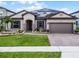 Charming single-story home with a manicured lawn, brick driveway, beautiful landscaping and solar panels at 5029 Hartwell Ct, St Cloud, FL 34771