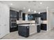 Modern kitchen with an island and pendant lights and stainless steel appliances and sleek dark cabinetry at 5029 Hartwell Ct, St Cloud, FL 34771
