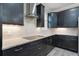 Modern kitchen with stainless steel appliances, sleek dark cabinetry and stone countertops with cooktop and subway tile backsplash at 5029 Hartwell Ct, St Cloud, FL 34771