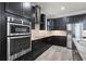 Modern kitchen with stainless steel appliances, sleek dark cabinetry and stone countertops and subway tile backsplash at 5029 Hartwell Ct, St Cloud, FL 34771