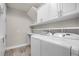 Well-equipped laundry room with white cabinets, shelving, and modern washer and dryer at 5029 Hartwell Ct, St Cloud, FL 34771