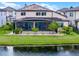 Back exterior view of a home with a screened-in patio and view of the water at 5029 Hartwell Ct, St Cloud, FL 34771