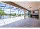 Spacious screened-in patio with a built-in grill, offering beautiful views of the serene lake at 5029 Hartwell Ct, St Cloud, FL 34771