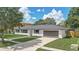 Well-maintained home with a lush green lawn, a dark grey roof, and a two-car garage at 5882 Marlberry Dr, Orlando, FL 32819