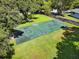 Outdoor basketball court surrounded by lush green grass, trees, and a partial perimeter wall at 641 Maple Oak Cir # 101, Altamonte Springs, FL 32701