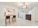 A dining area features bar seating, an elegant chandelier, and tiled floors leading to a carpeted stairway at 641 Maple Oak Cir # 101, Altamonte Springs, FL 32701