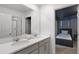 Bright bathroom featuring a double sink vanity with white countertops and a large mirror reflecting the shower at 8913 Coconut Breeze Dr, Kissimmee, FL 34747