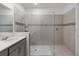 A modern bathroom features a glass enclosed shower, neutral tiles and a stylish vanity at 8913 Coconut Breeze Dr, Kissimmee, FL 34747