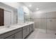 A bright bathroom boasts a double sink vanity, a glass enclosed shower and neutral tiles at 8913 Coconut Breeze Dr, Kissimmee, FL 34747