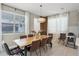 Dining area featuring a large wooden table with seating for eight, complemented by modern decor and natural light at 8913 Coconut Breeze Dr, Kissimmee, FL 34747