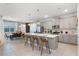 Open-concept kitchen with gray cabinetry, stainless steel appliances, a center island with bar stools, and modern pendant lighting at 8913 Coconut Breeze Dr, Kissimmee, FL 34747