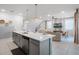Open kitchen with a large island, stainless steel dishwasher, and seamless flow into the living and dining areas at 8913 Coconut Breeze Dr, Kissimmee, FL 34747