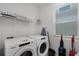 Bright laundry room with side by side washer and dryer, a storage shelf, and natural light to make laundry enjoyable at 8913 Coconut Breeze Dr, Kissimmee, FL 34747