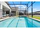 Sparkling screened-in pool and spa area, offering a refreshing escape in a private backyard at 8913 Coconut Breeze Dr, Kissimmee, FL 34747