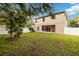 View of the home's rear exterior from the backyard, showcasing a covered patio at 9067 Stonebury Way, Orlando, FL 32832