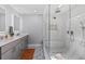 Modern bathroom featuring double vanity, decorative floor tile, and a glass shower enclosure at 9067 Stonebury Way, Orlando, FL 32832