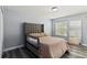 Bedroom featuring wood-look flooring, a window, and neutral decor at 9067 Stonebury Way, Orlando, FL 32832